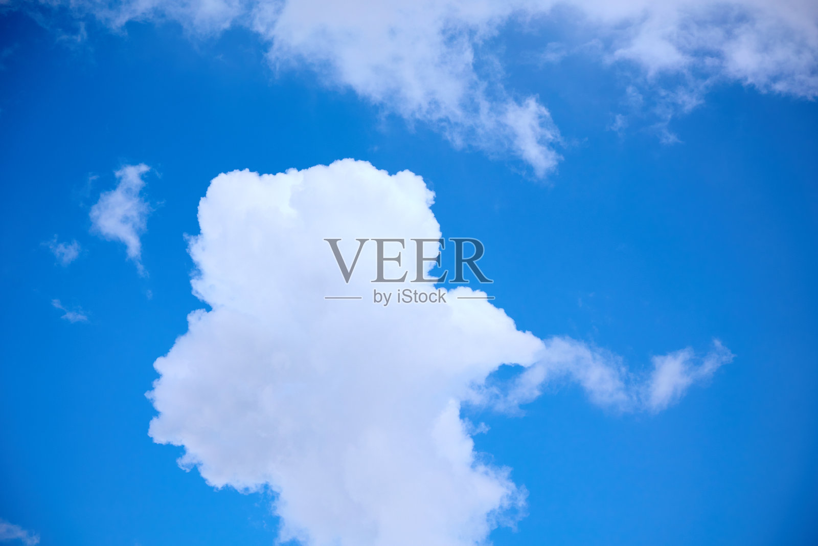 一大朵十字形的白云漂浮在晴朗的蓝天上照片摄影图片