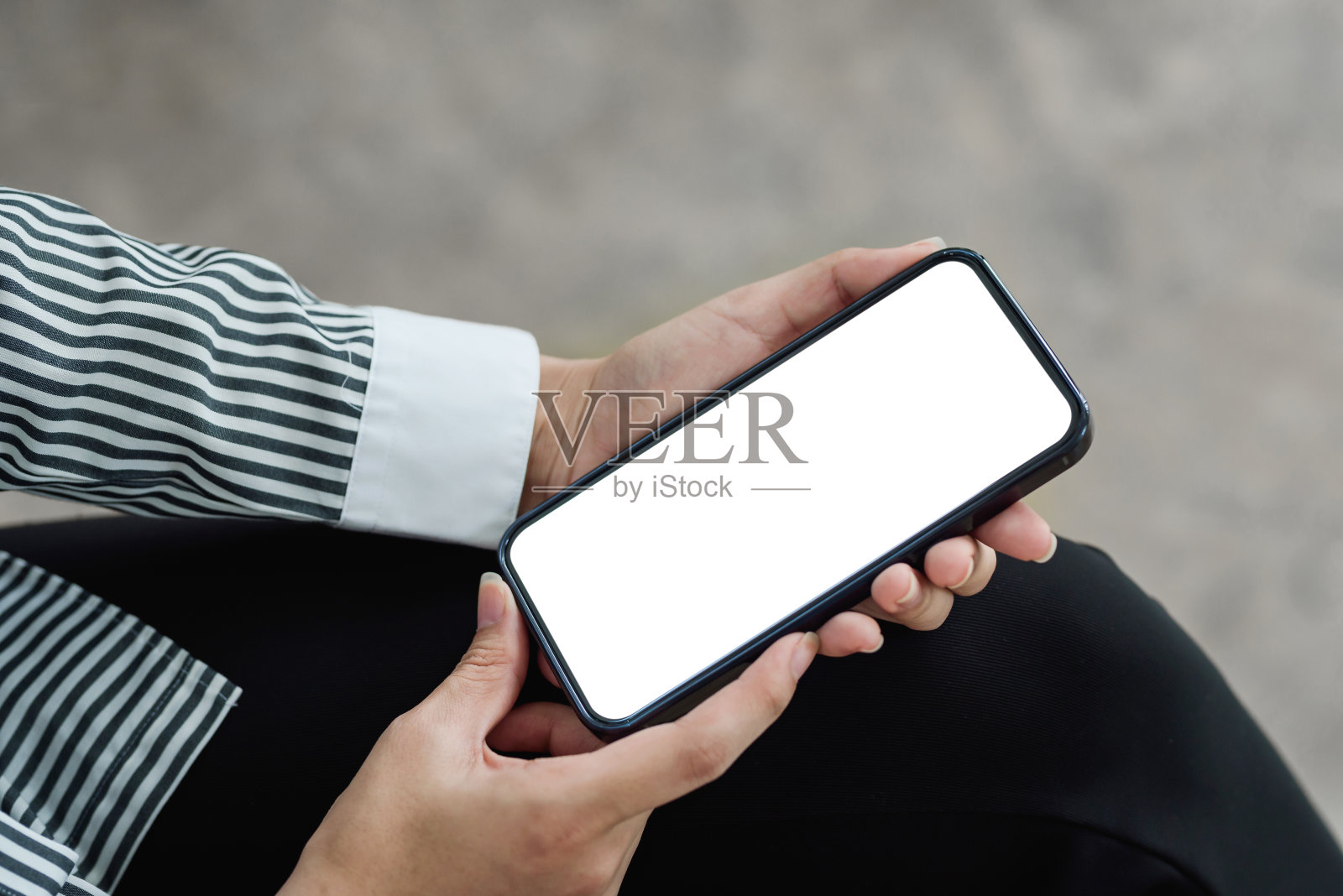 一位女士拿着一部空白的智能手机坐在café网站上。模拟了照片摄影图片