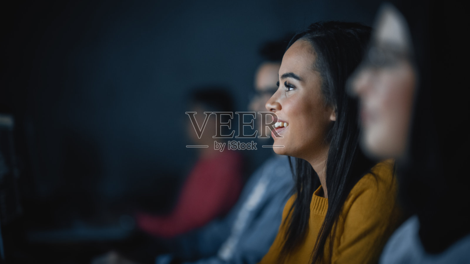 不同种族的男女学生坐在大学房间里，在电脑上合作完成学校的项目。青年学者在课堂上学习、讲、用。照片摄影图片