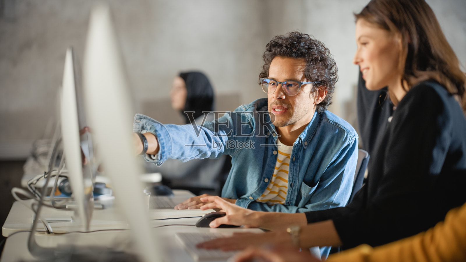 聪明的年轻学生在大学与不同种族的同学学习。学者们在大学房间与电脑合作。在课堂上运用知识获取学术技能。照片摄影图片