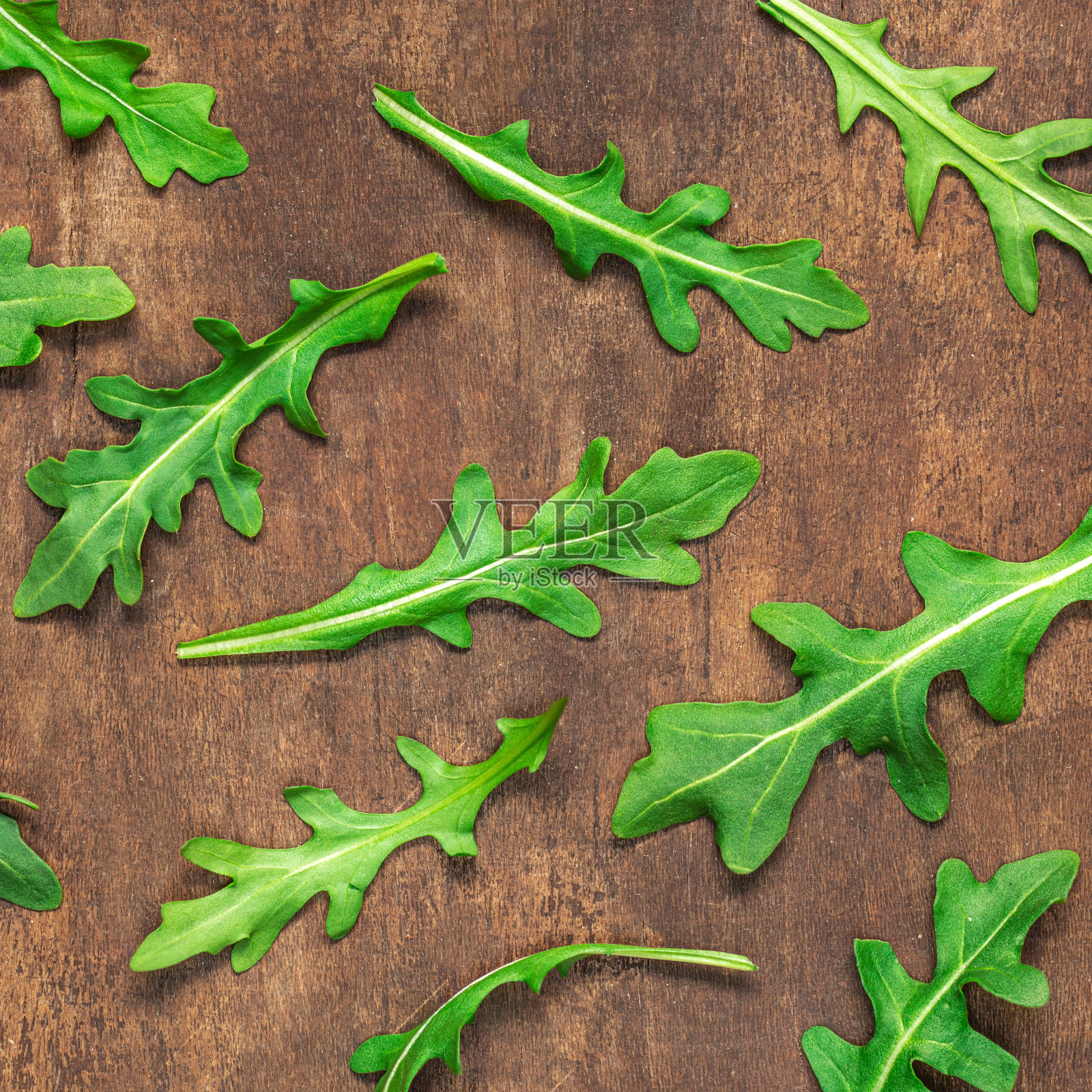 菜叶放在木桌上，鲜绿的芝麻叶收藏俯视图。“n照片摄影图片