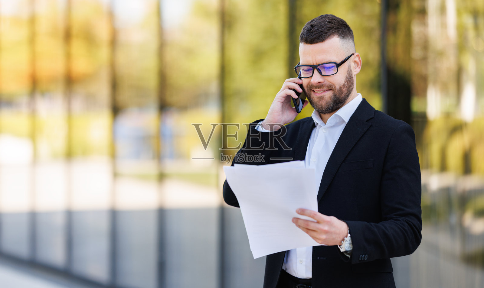 专注于严肃的商业律师用手机与客户交谈，阅读合同文件照片摄影图片