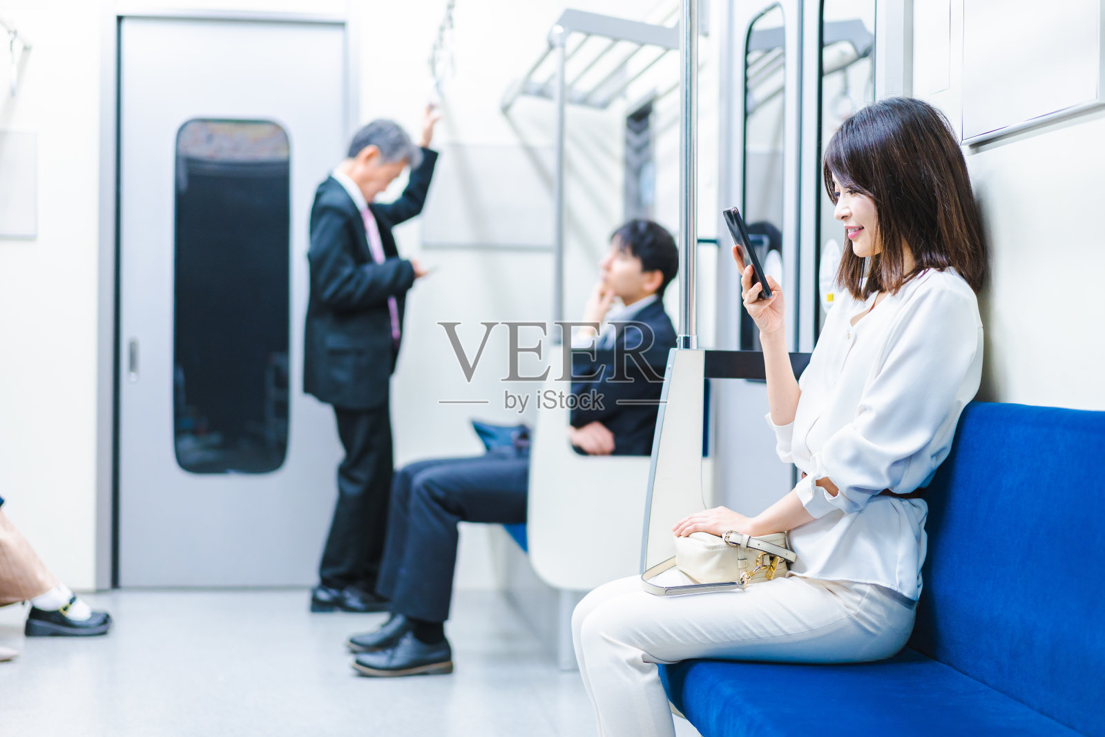 一位年轻女子在火车上使用智能手机照片摄影图片