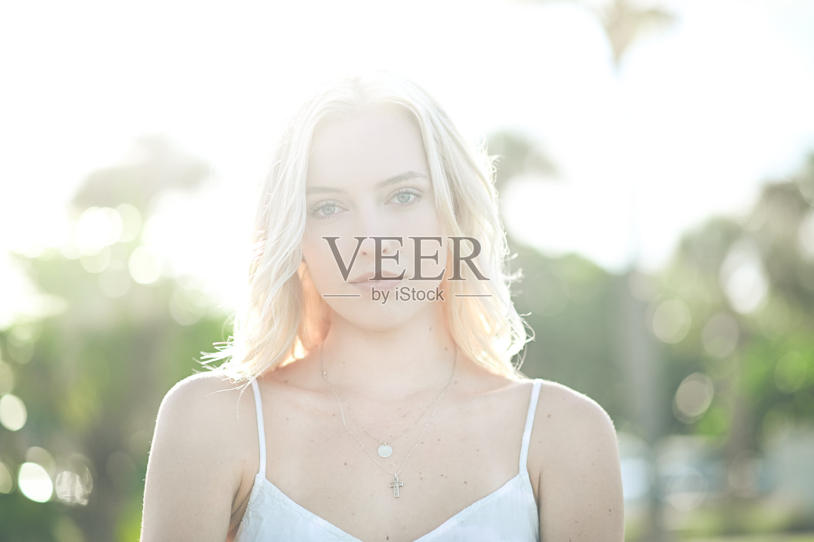 年轻女子与中等长度的金发看着相机在夏天的头照照片摄影图片