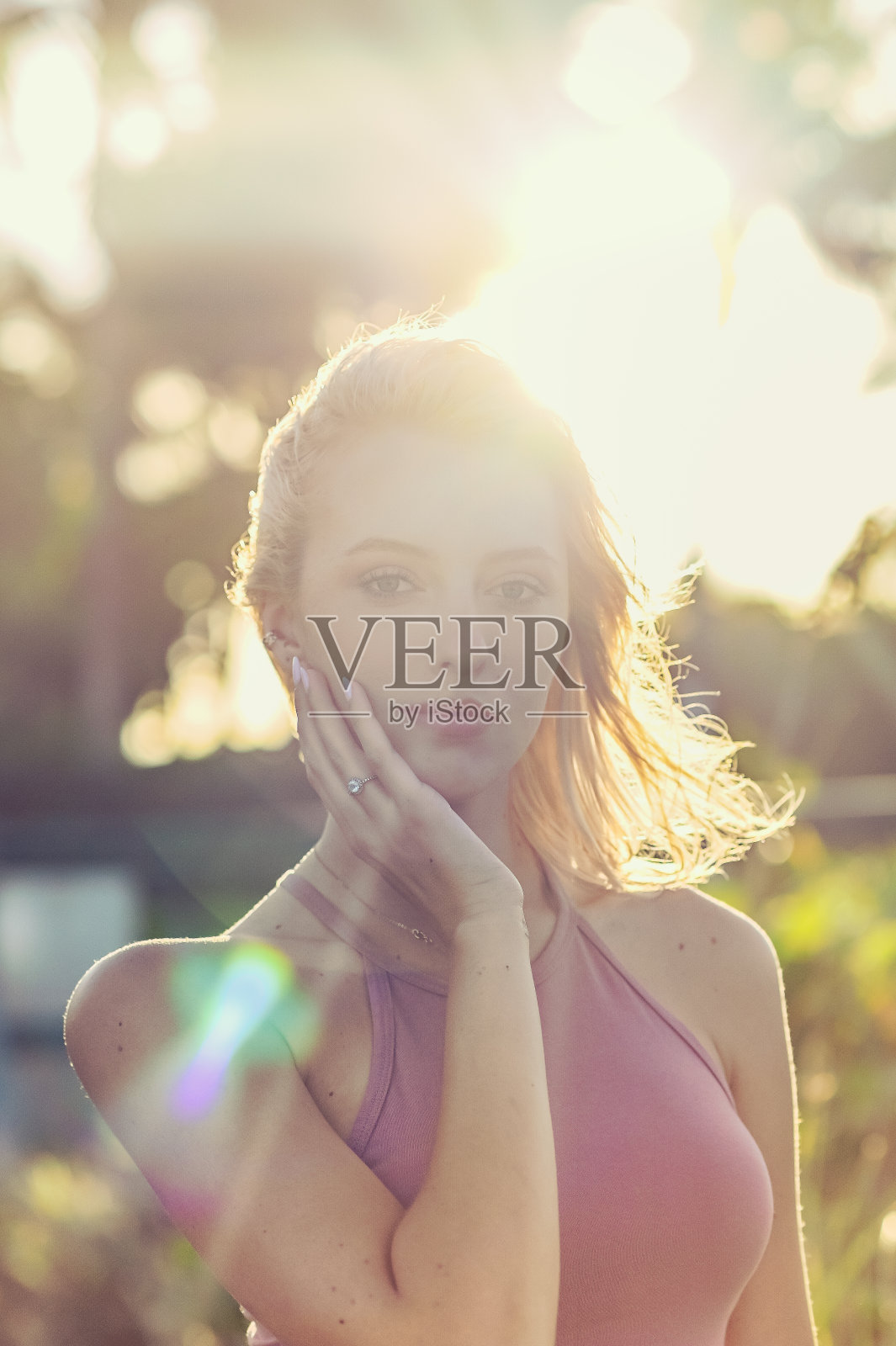 美丽的年轻女子抚摸她的脸在阳光明媚的夏天肖像照片摄影图片