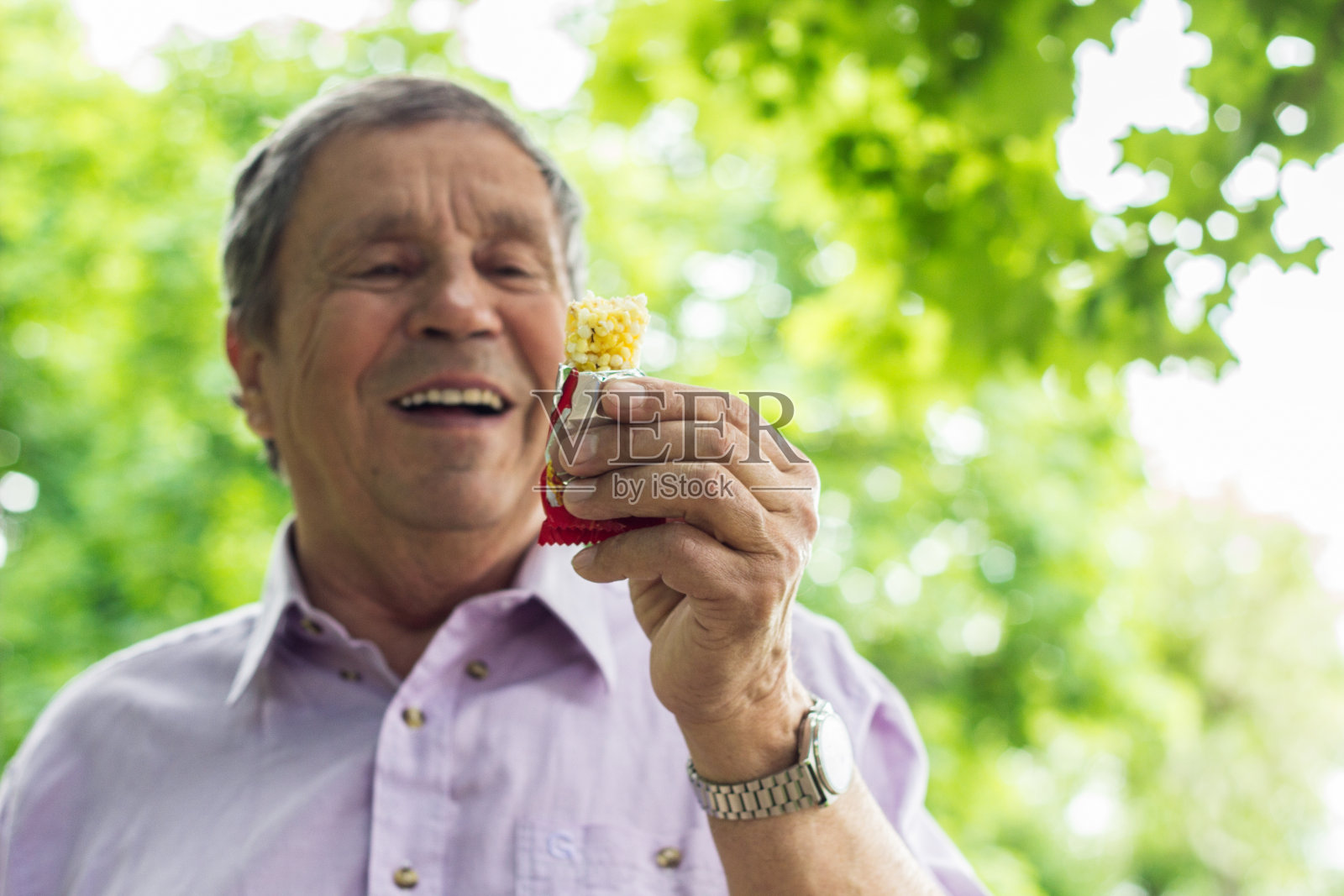 老人在吃蛋白质棒照片摄影图片