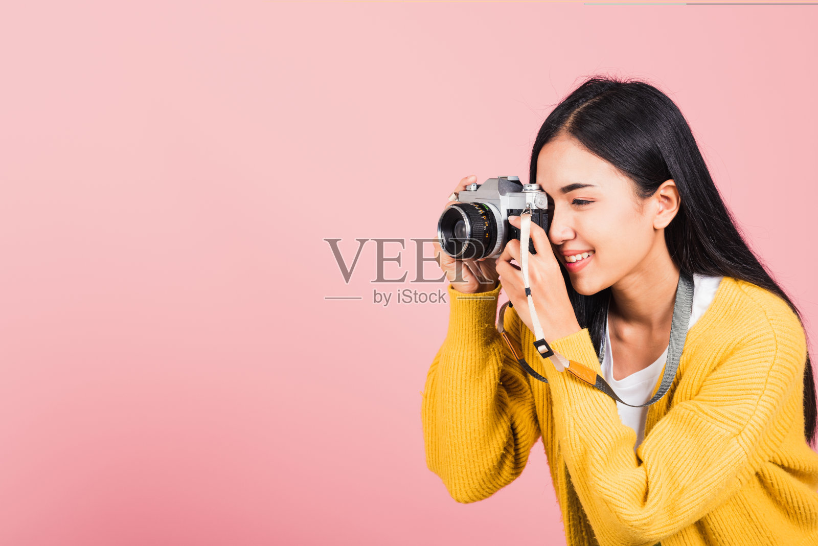 女人微笑的摄影师拍照，看着取景器的复古照片相机照片摄影图片