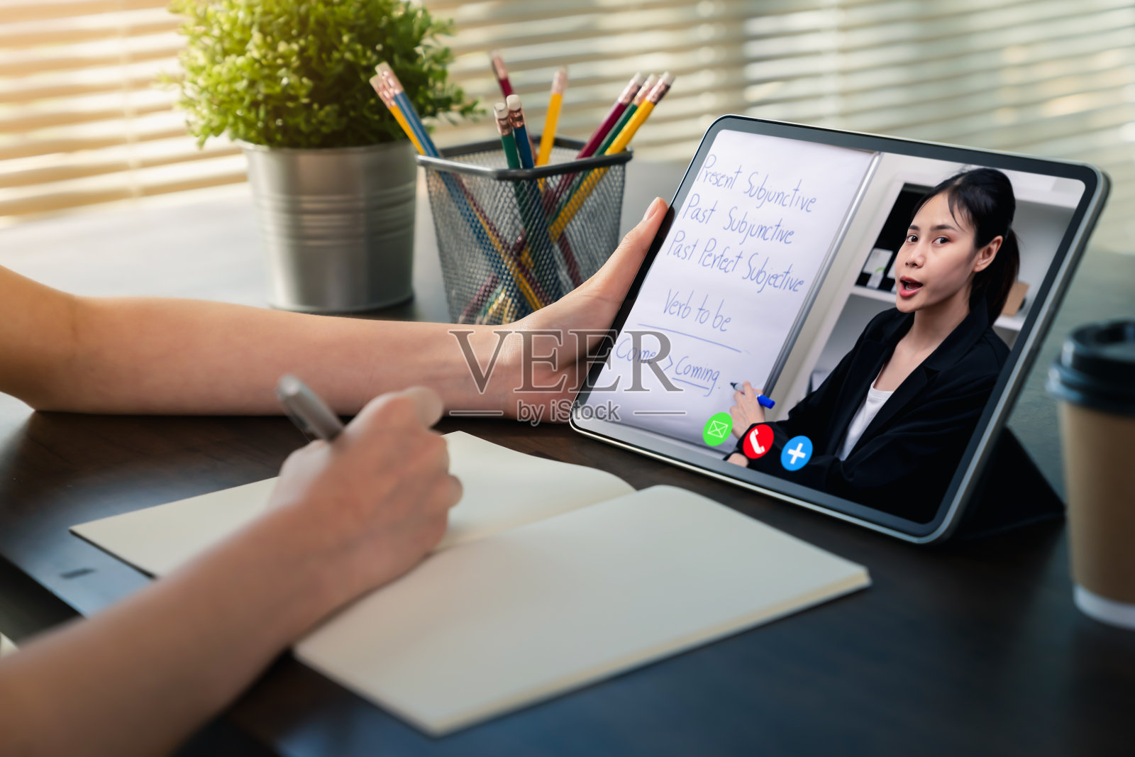 在家学习的概念，年轻女性通过视频会议在数字平板电脑上在线观看课程。照片摄影图片