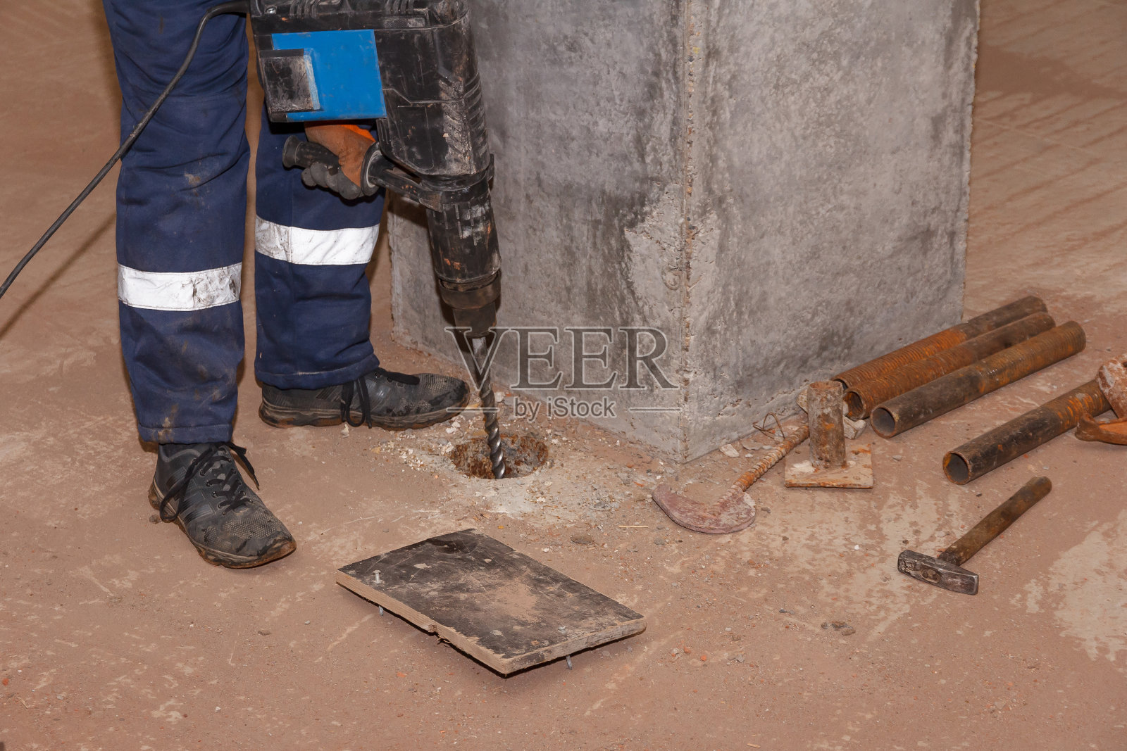 工人用手提钻。男工人用手提钻钻和修补混凝土表面照片摄影图片