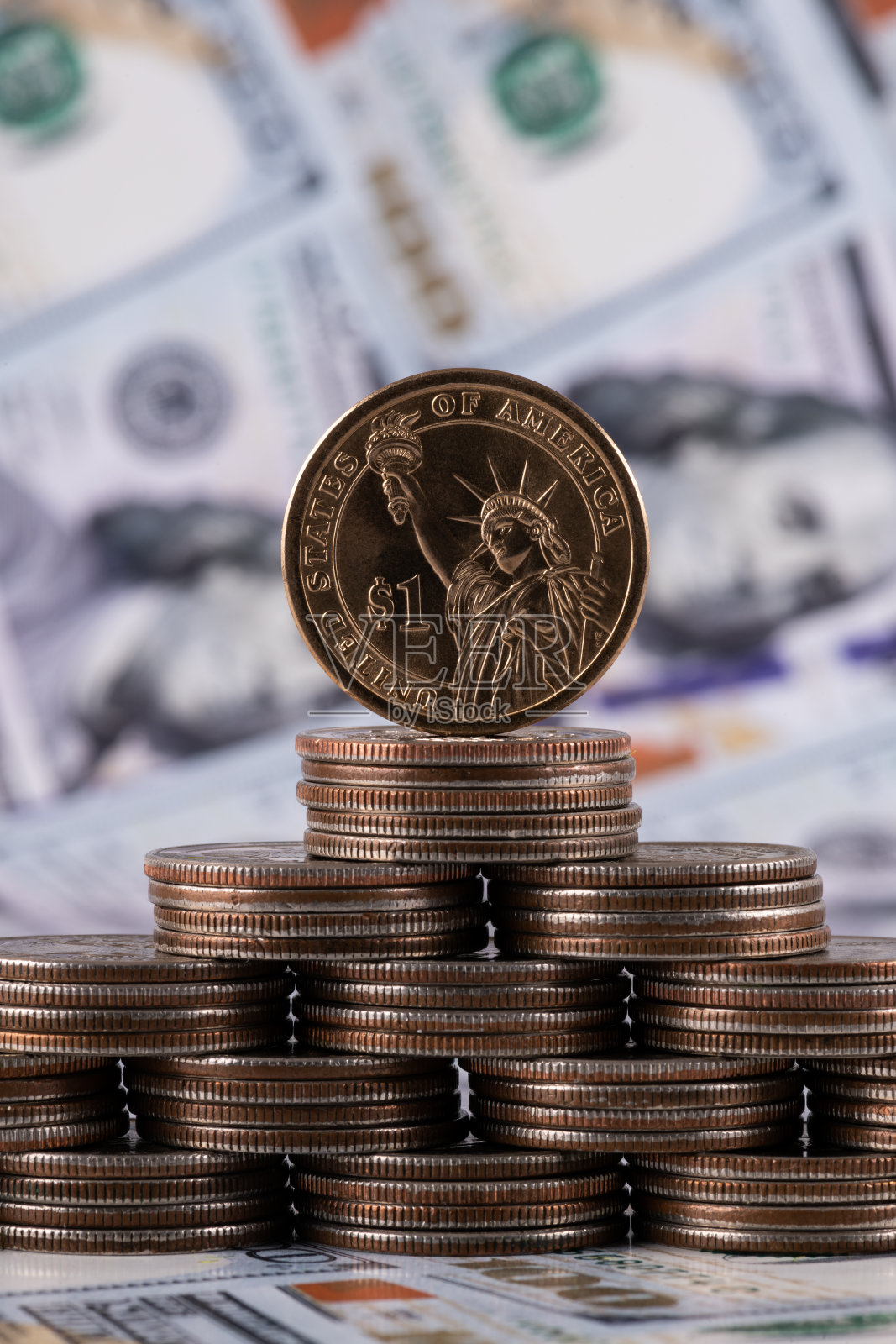 以100张美元钞票为背景的美国硬币的金字塔照片摄影图片