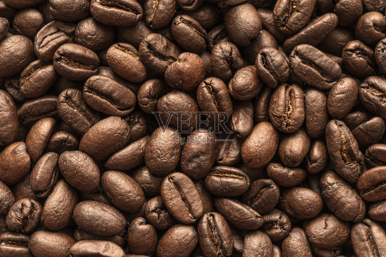 咖啡豆的背景。关闭了。桌子上磨砂咖啡豆的微距照片。照片摄影图片