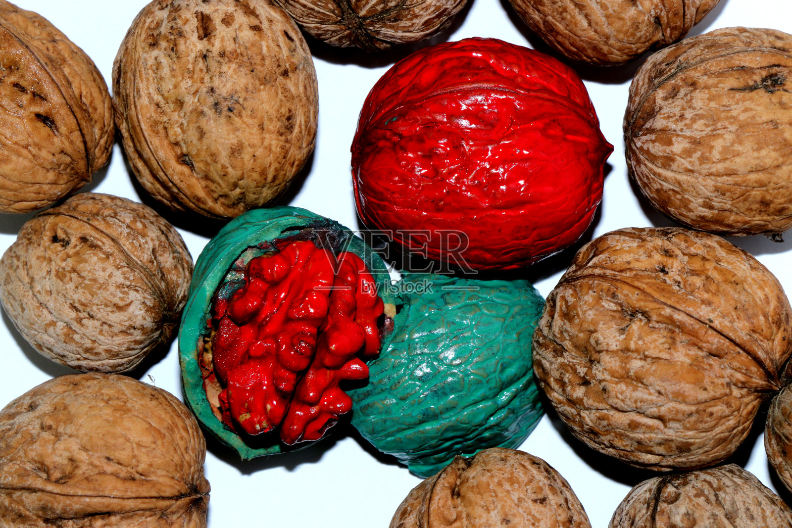 大量的核桃，其中一个是绿色的，核是红色的，另一个是红色的照片摄影图片