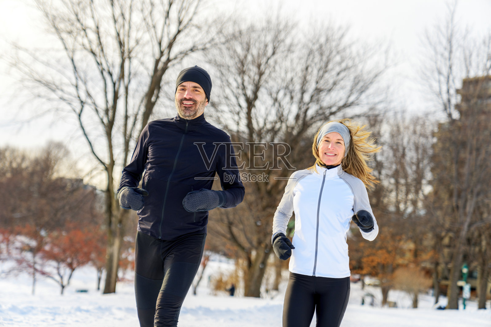 成熟的情侣在冬天一起在大自然中奔跑照片摄影图片