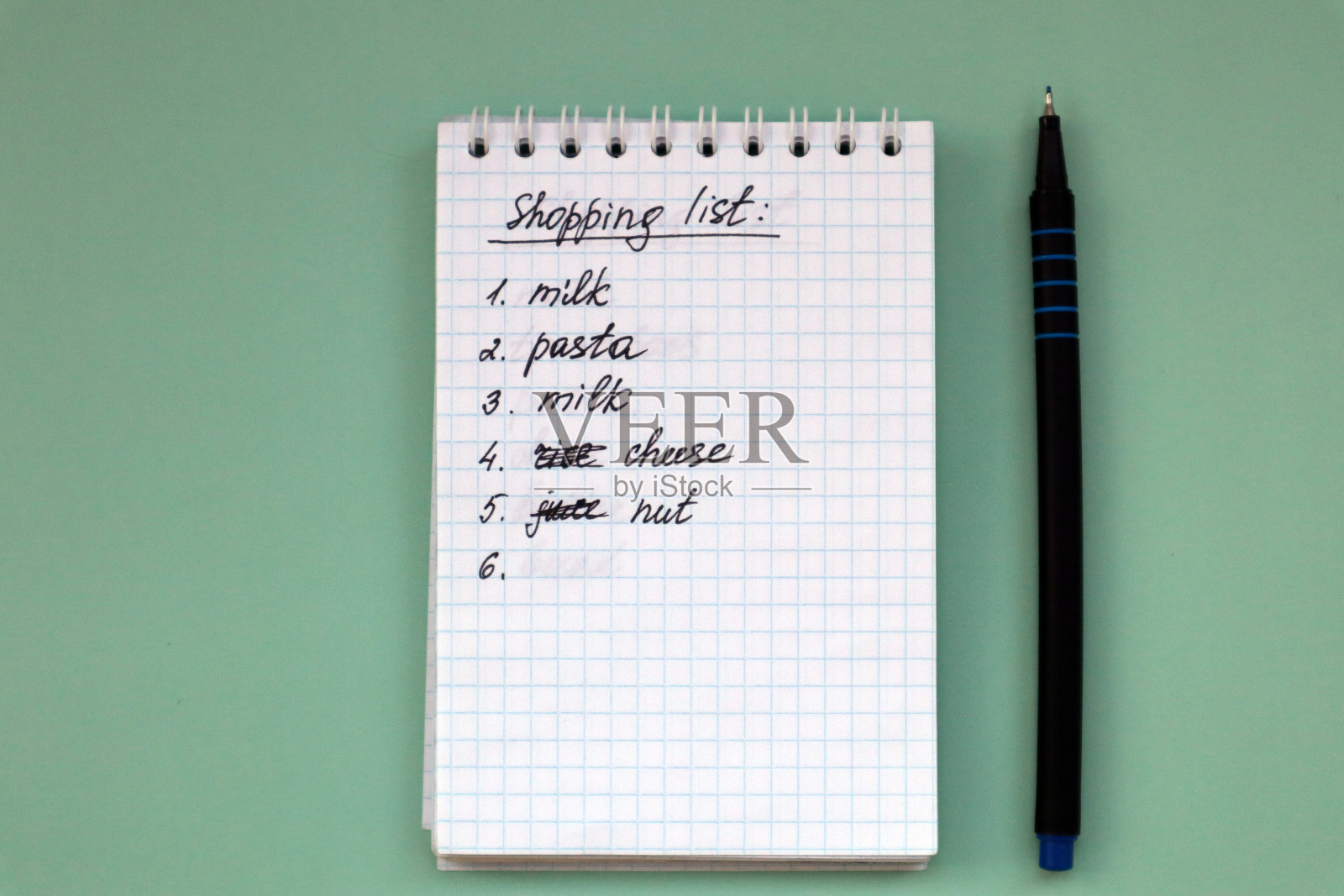 带购物清单的绿色背景笔记本和有复制空间的钢笔。照片摄影图片