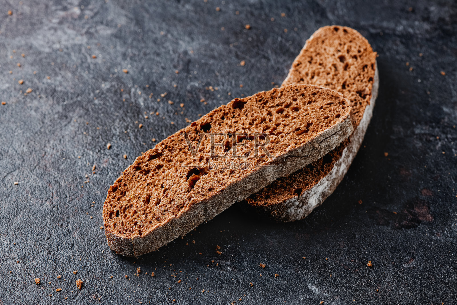 黑麦面包片在黑色的石头表面照片摄影图片