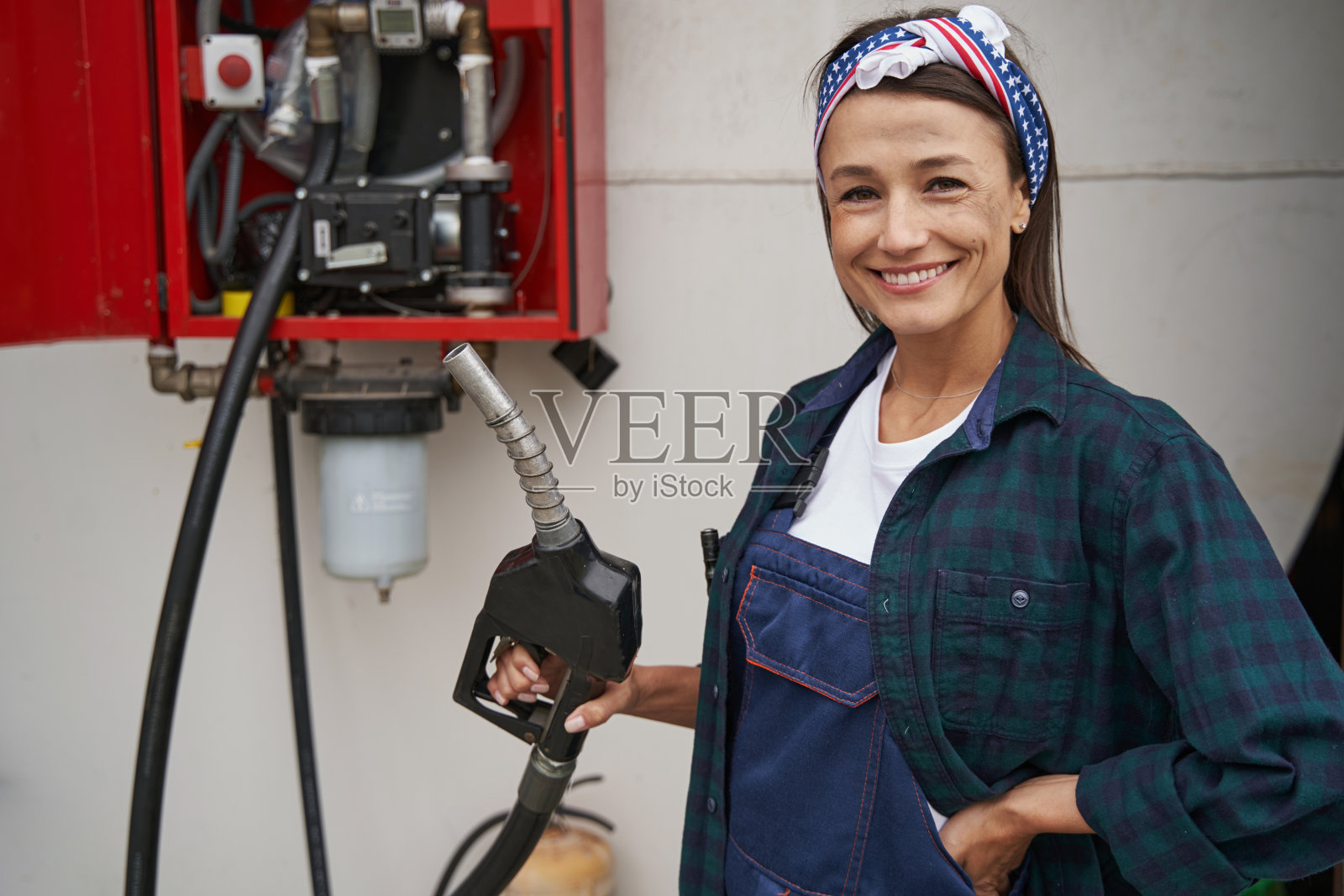微笑的漂亮白人女性与红色燃料泵孤立在白色背景照片摄影图片
