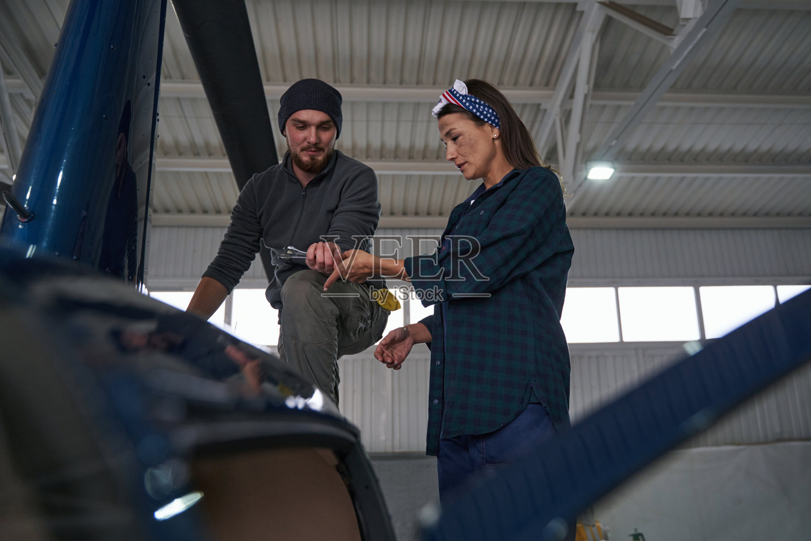 积极的航空工程师在现代化和翻新的直升机在机库照片摄影图片