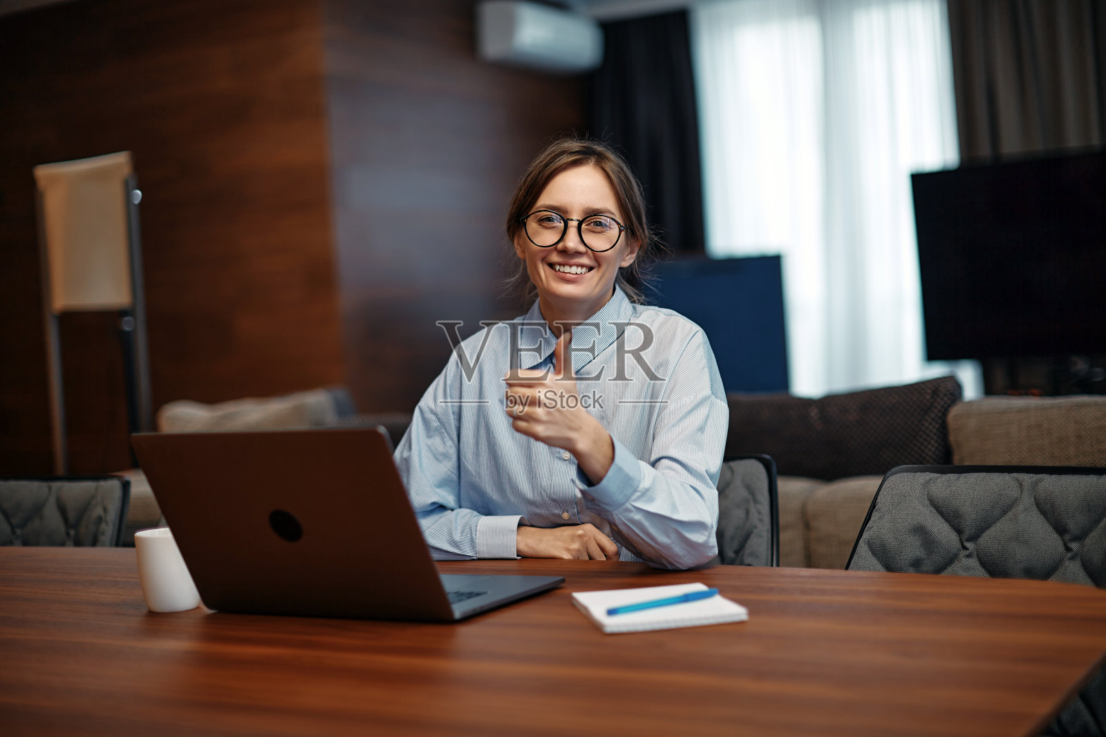 满意的小女孩微笑着坐在笔记本电脑显示拇指手势，推荐在线教育课程，电子学习应用程序照片摄影图片