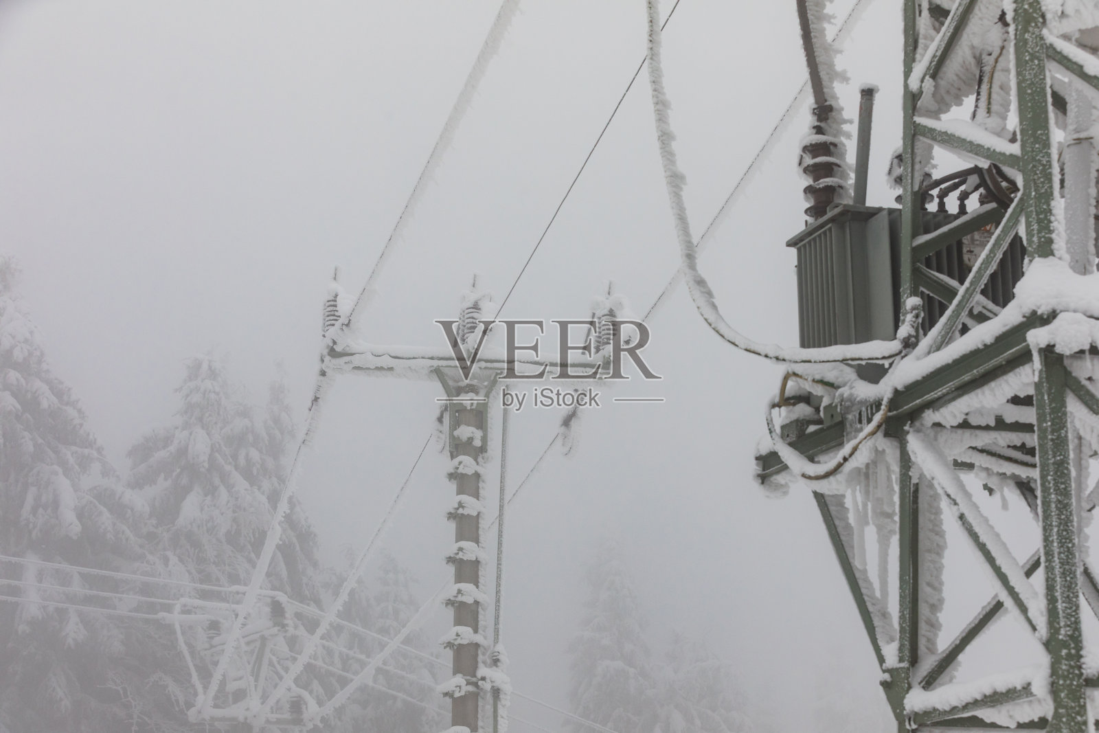 冻结的电线塔。高压电缆和电塔上结霜。冬天在山区。照片摄影图片