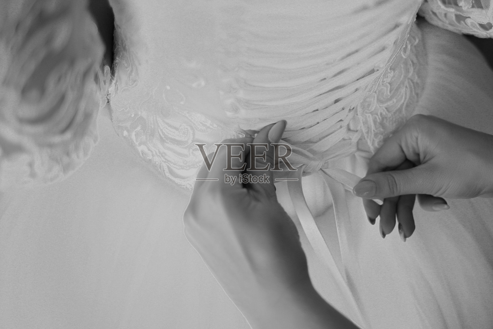 时装设计师正在修改婚纱。早上准备。女人穿上裙子。照片摄影图片