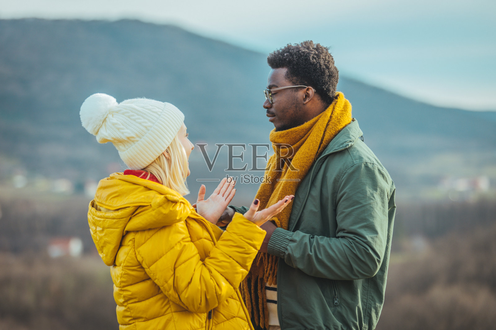 在金黄色的草地上，男女手牵着手照片摄影图片