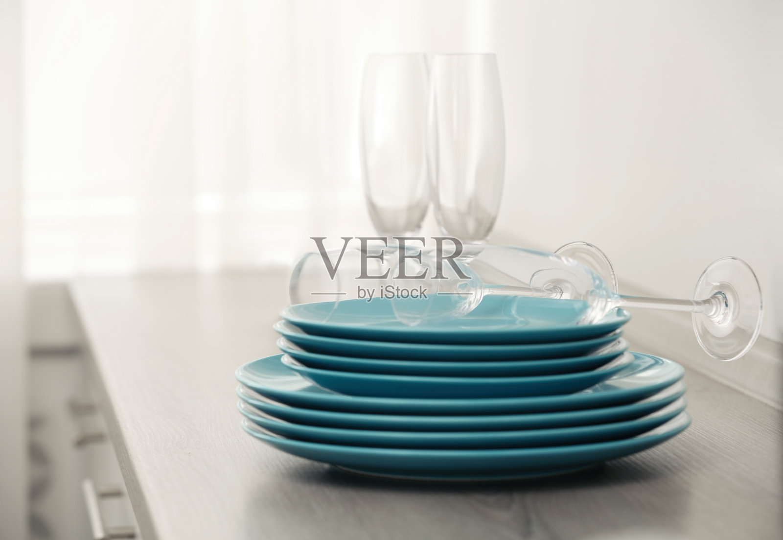 一套干净的餐具和香槟酒杯放在室内的桌子上照片摄影图片