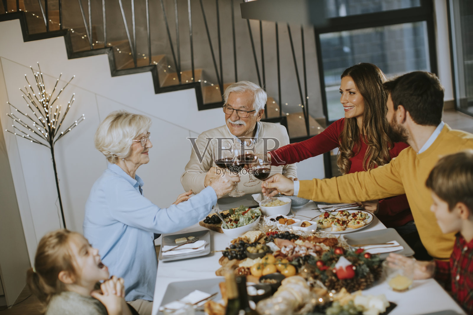 幸福的一家人在家里吃晚餐，喝红酒照片摄影图片