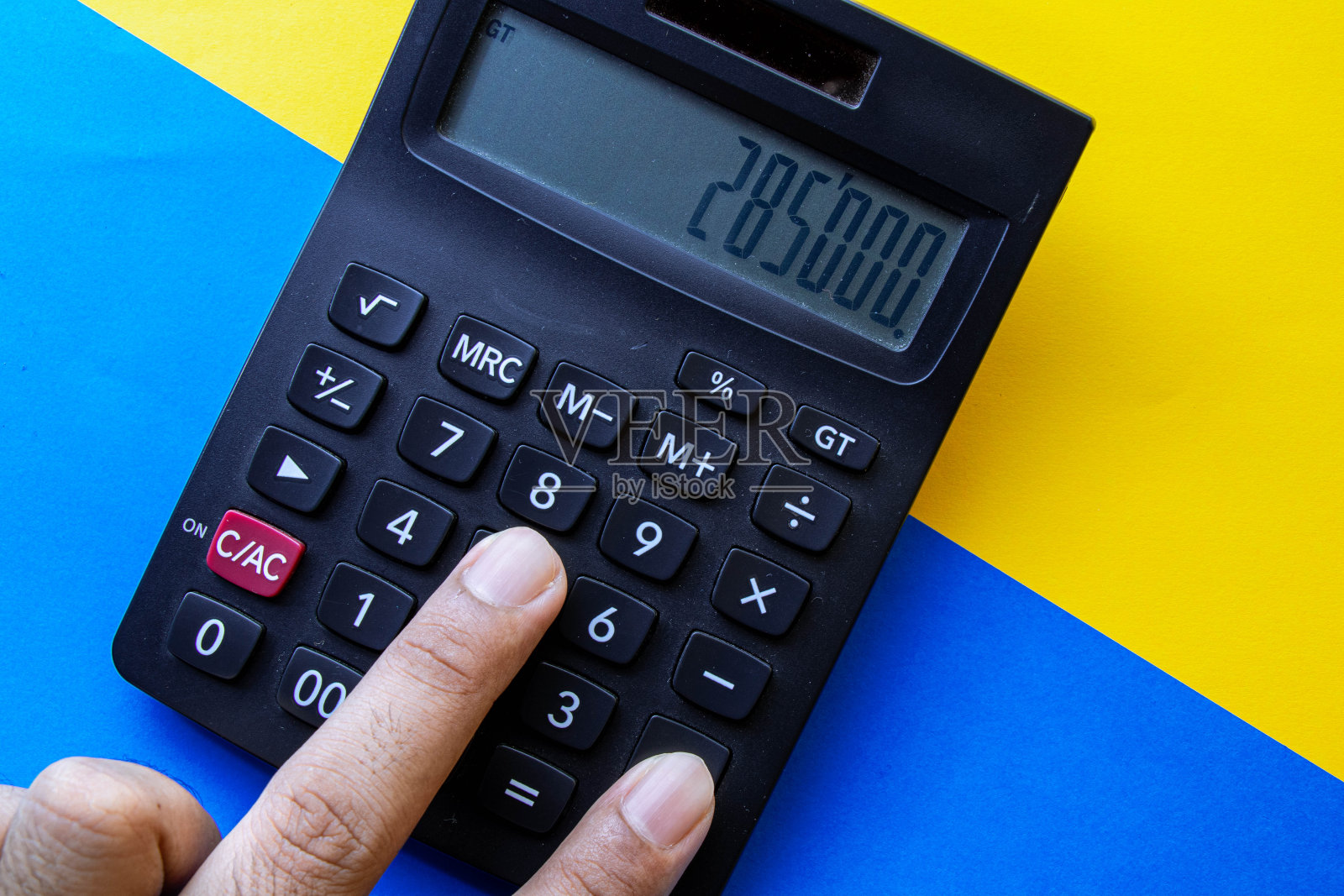 在彩色背景上使用计算器的人照片摄影图片