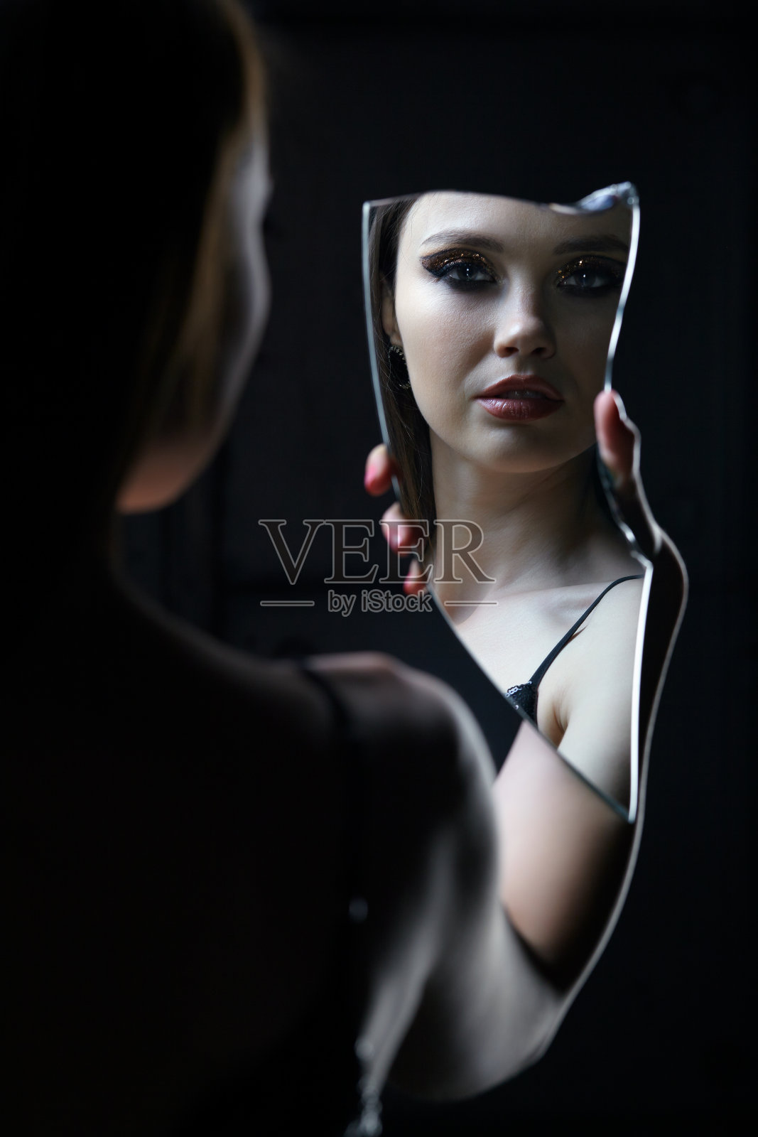 有镜子碎片的女性。美丽的年轻女子肖像照片摄影图片