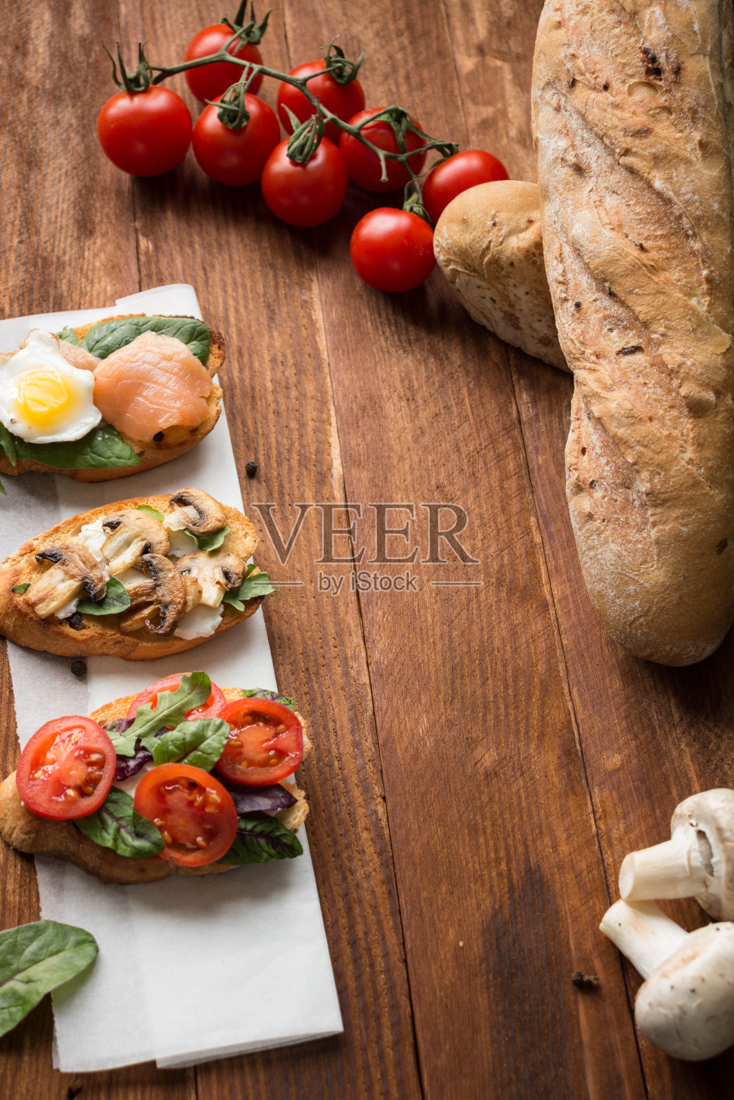 桌上放着不同种类的烤面包，番茄，三文鱼，蘑菇和鸡蛋照片摄影图片