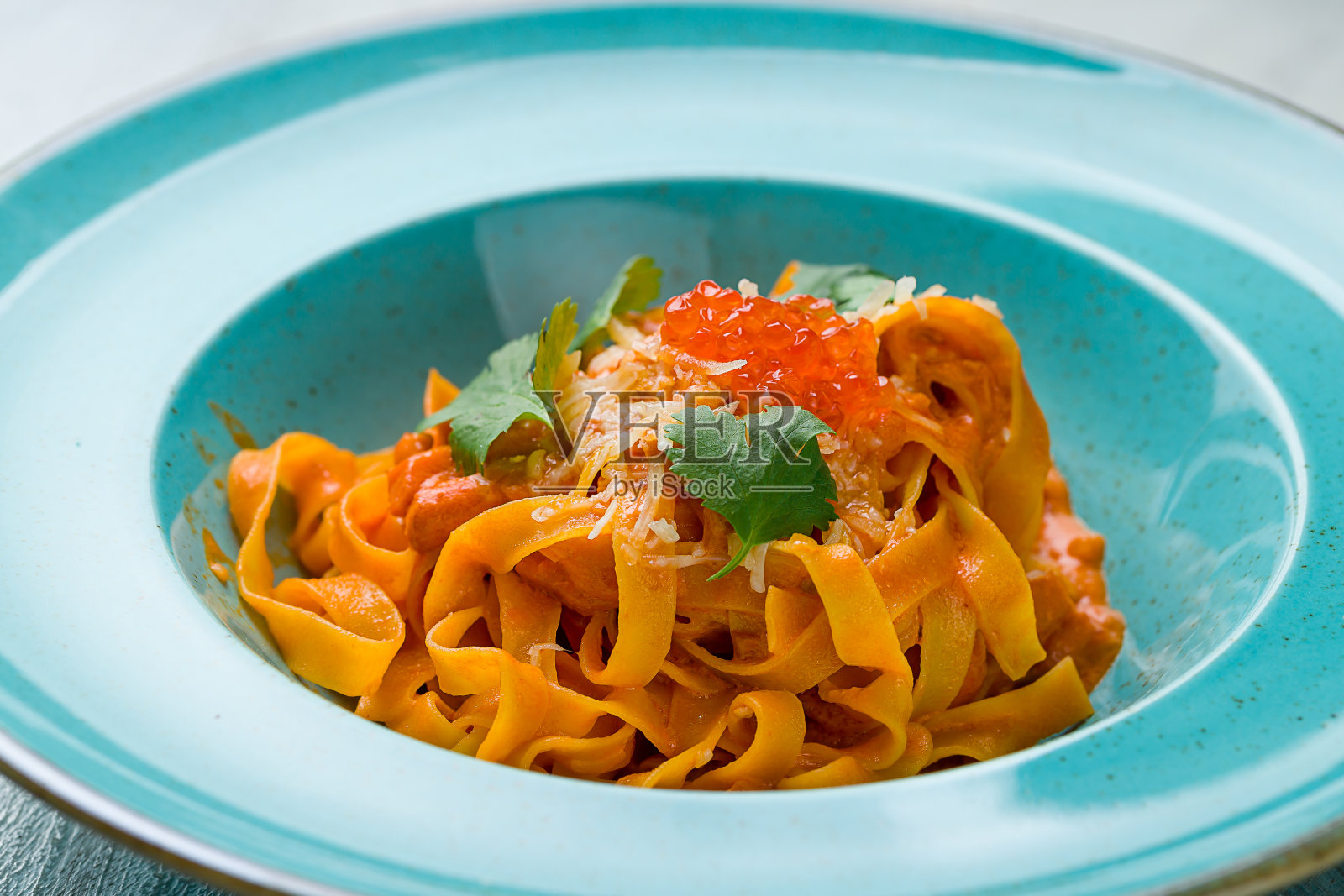 灰色桌子上的鲑鱼和红色鱼子酱意大利面宏近照片摄影图片