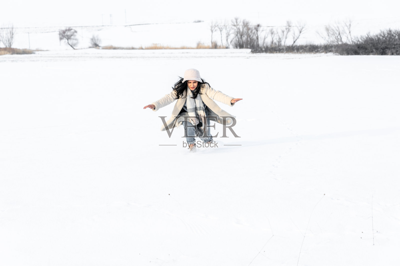 年轻女子在冬天的雪地里玩得很开心照片摄影图片
