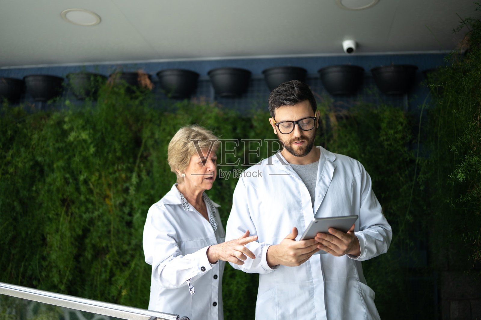 医生们在诊所里用数码平板电脑交谈和使用照片摄影图片