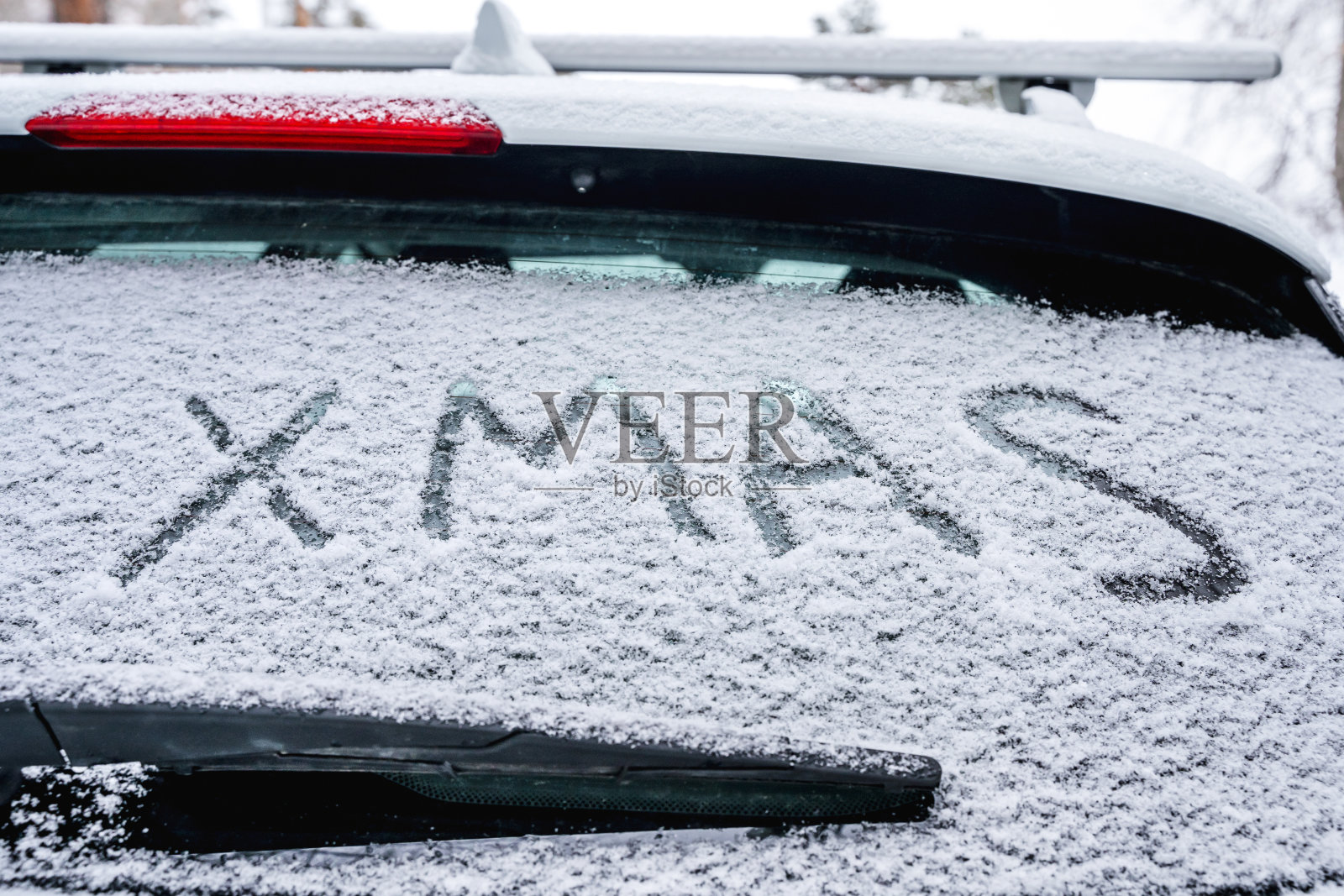 在冬天的雪地上，车的挡风玻璃上画着“圣诞节”的题词。圣诞节的概念照片摄影图片