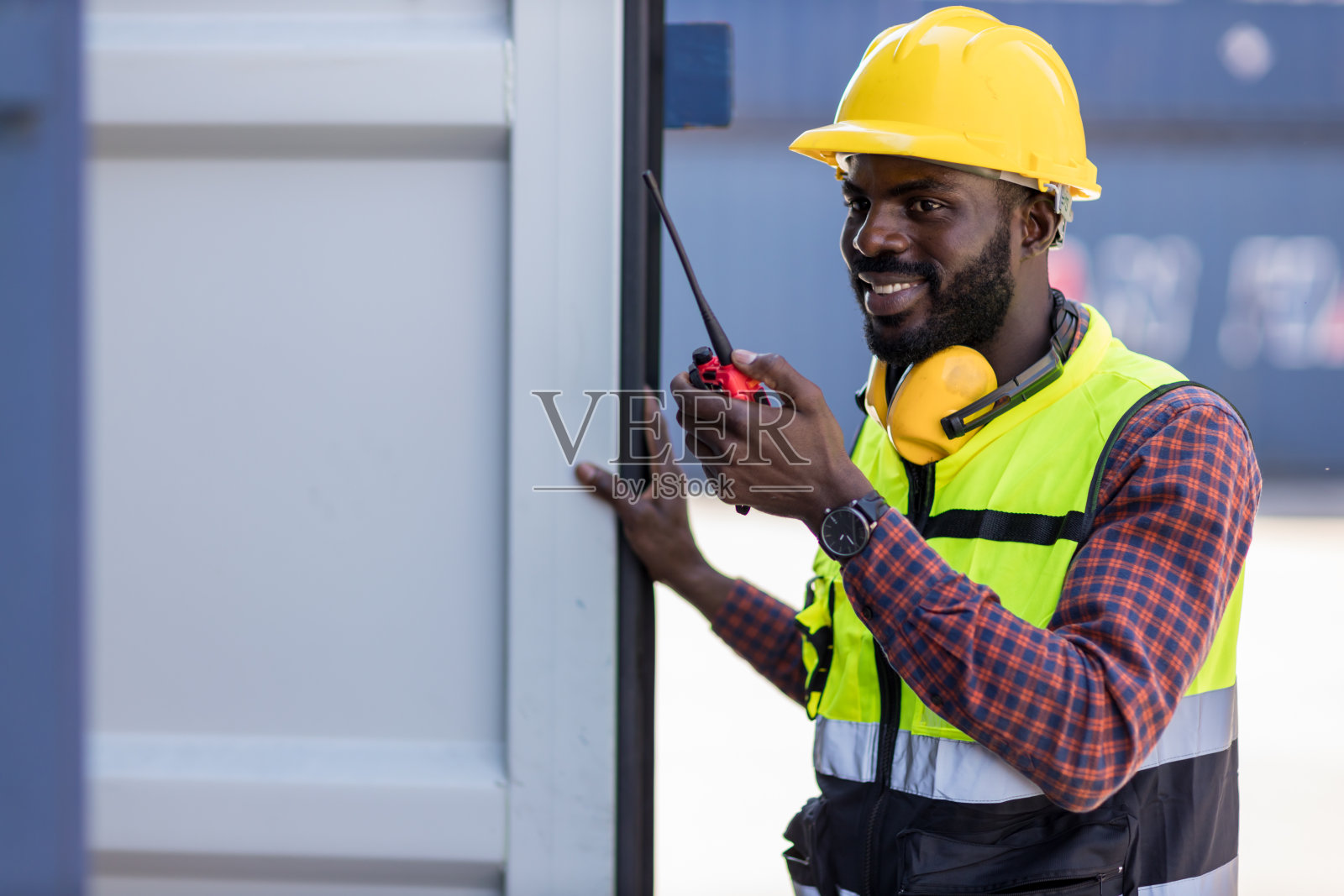 集装箱货场领班手持对讲机进行控制工作。户外手持对讲机照片摄影图片