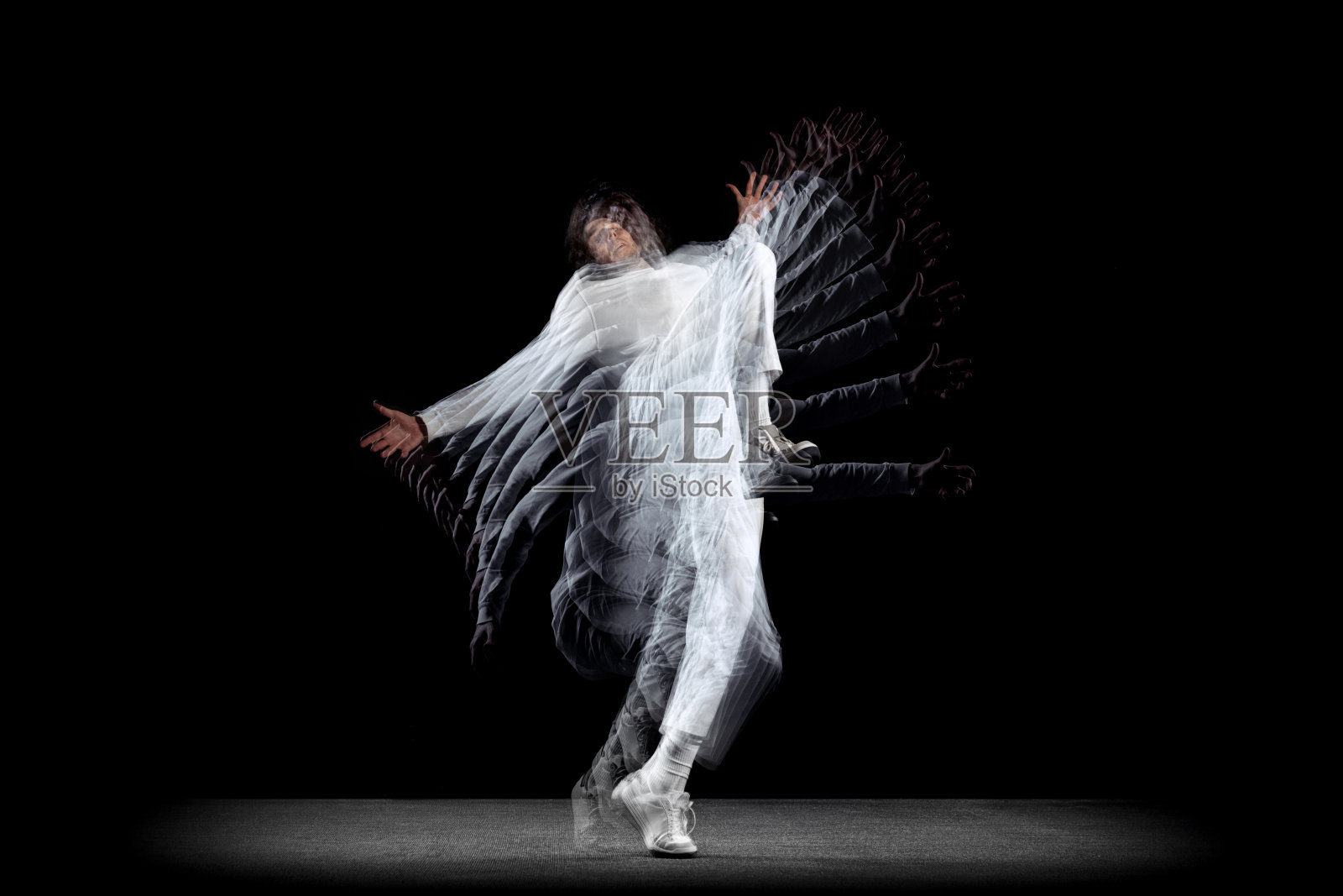 年轻人，动作中的嘻哈舞者，在黑暗的背景下运动，带有sroboscope效果。青年文化，嘻哈，运动，时尚，时尚，行动。照片摄影图片