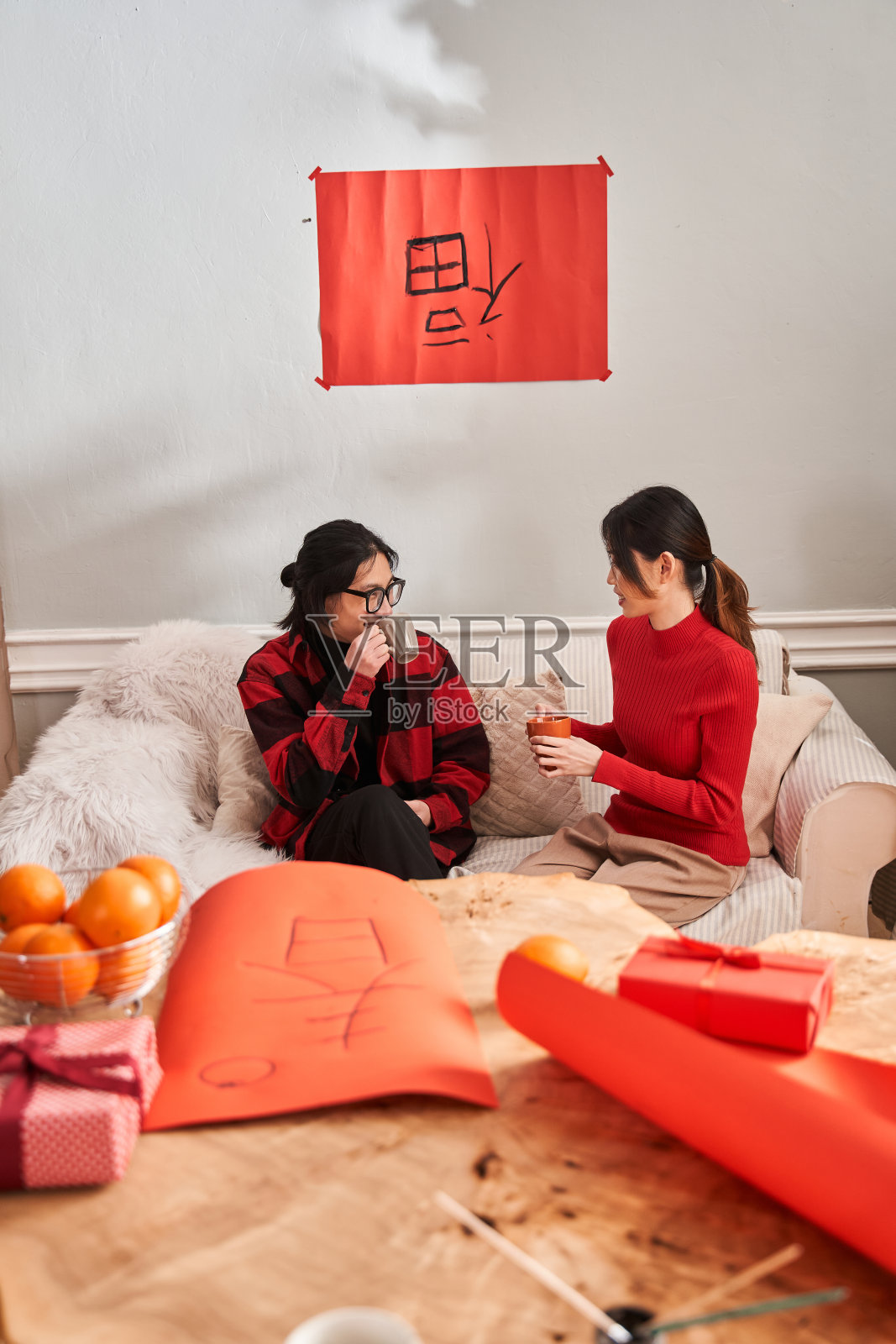 幸福的亚洲夫妇坐在沙发边喝茶边聊天照片摄影图片