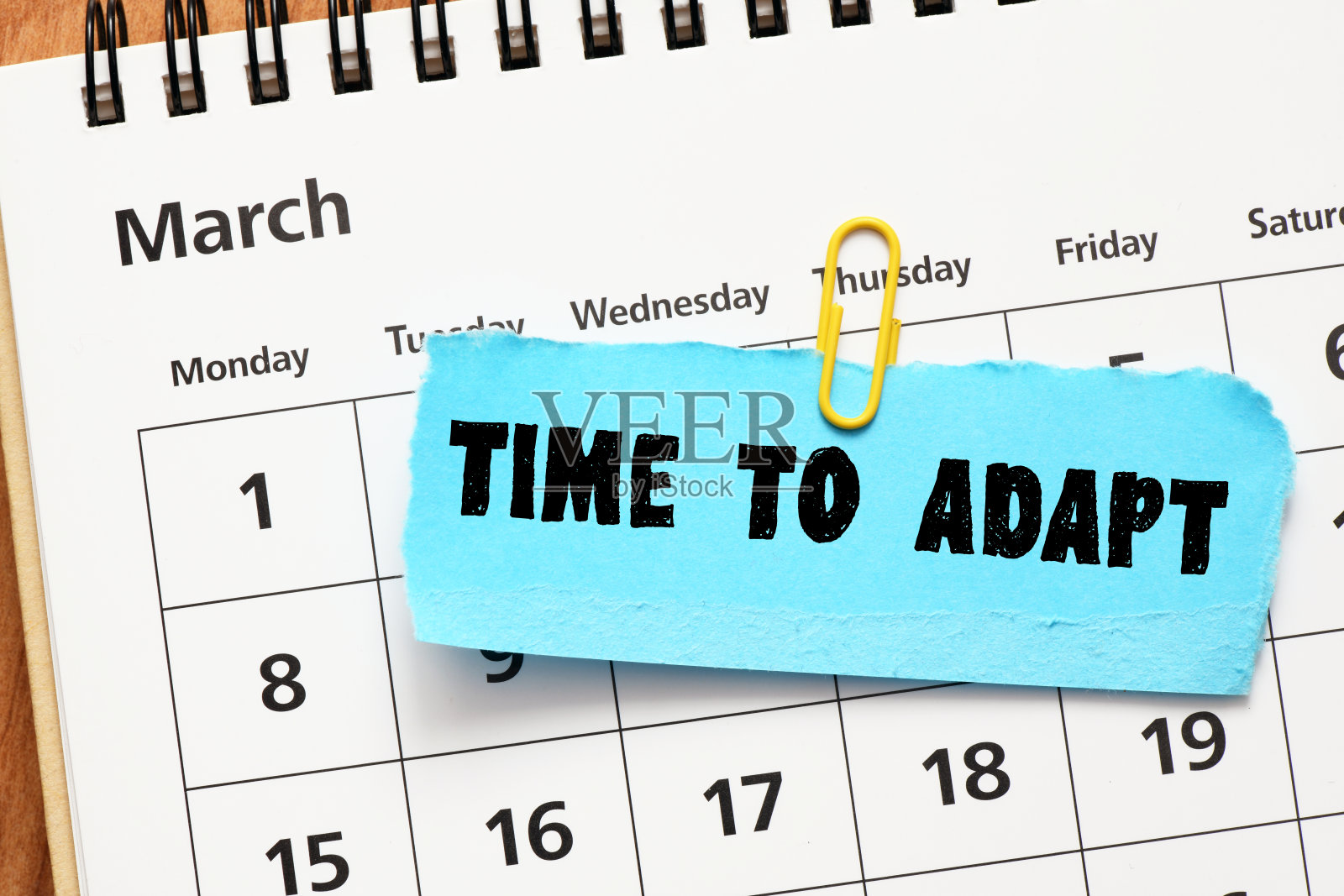 时间适应的文字写在一张蓝色的纸上放在日历上。在商业概念。照片摄影图片