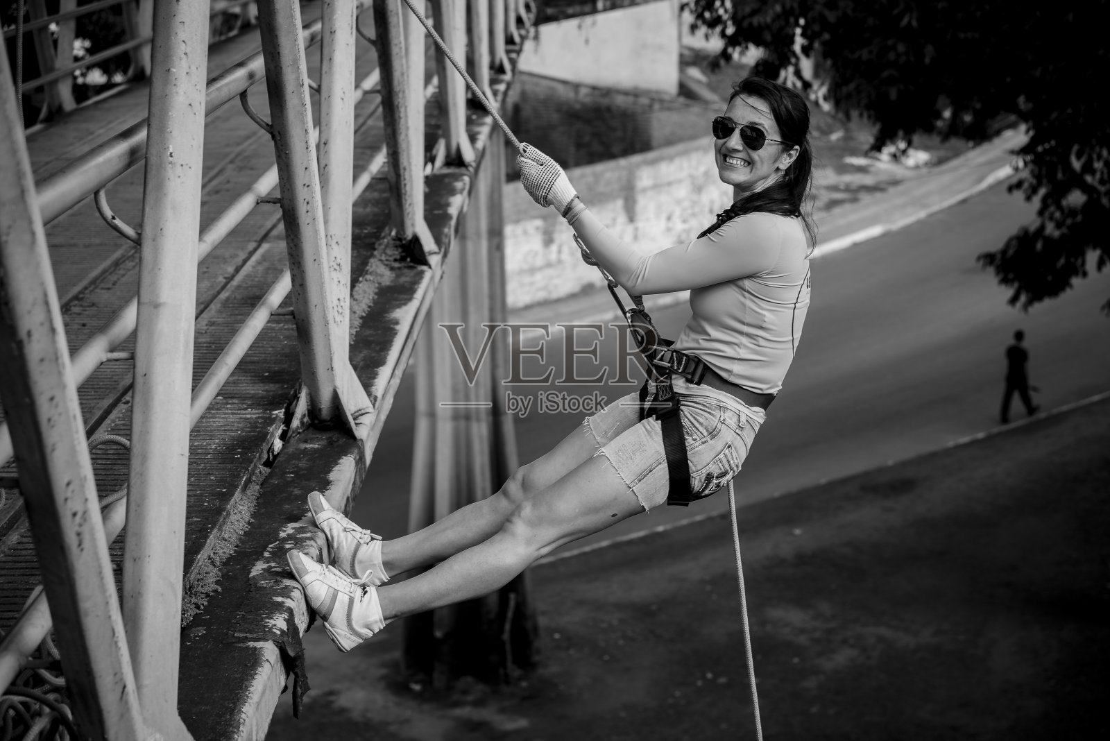 一个女人在人行道上练习绳降。照片摄影图片