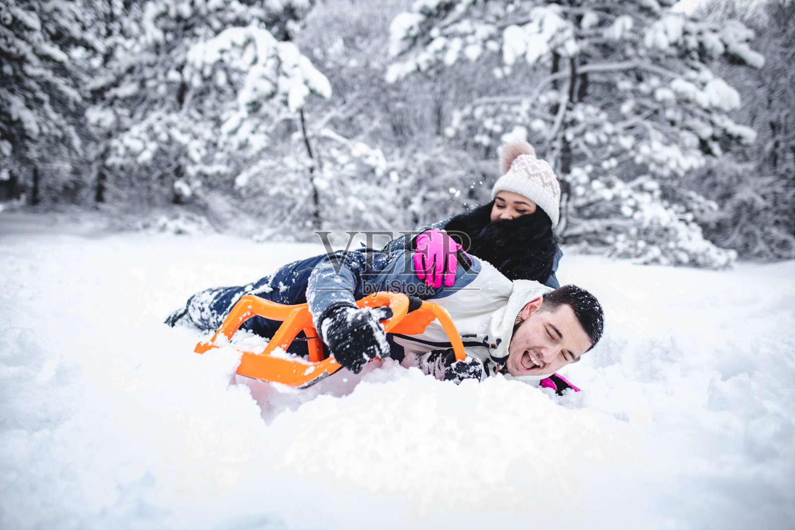 一对夫妻在雪地里滑雪，像孩子一样玩耍照片摄影图片