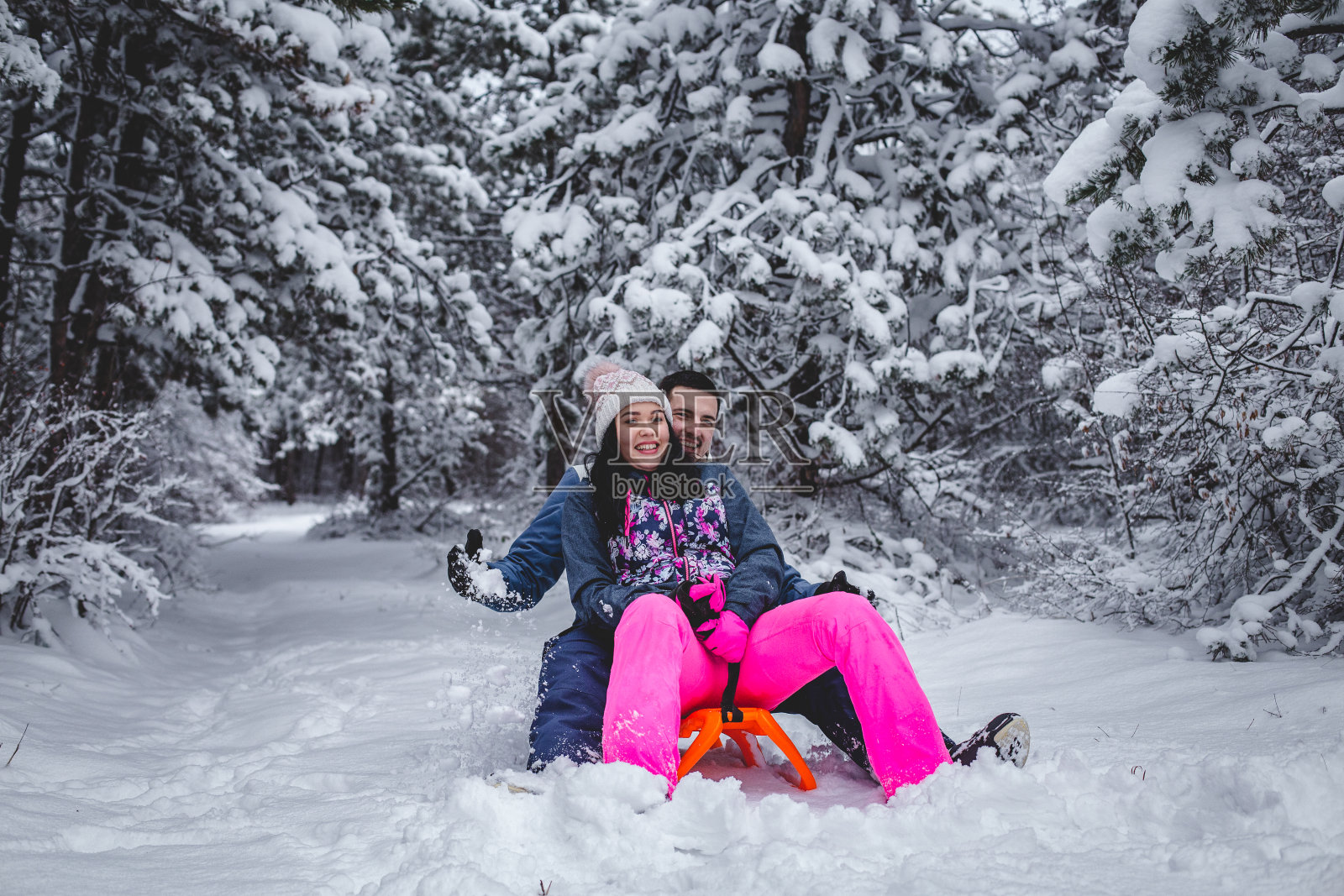 一对夫妻在雪地里滑雪，像孩子一样玩耍照片摄影图片