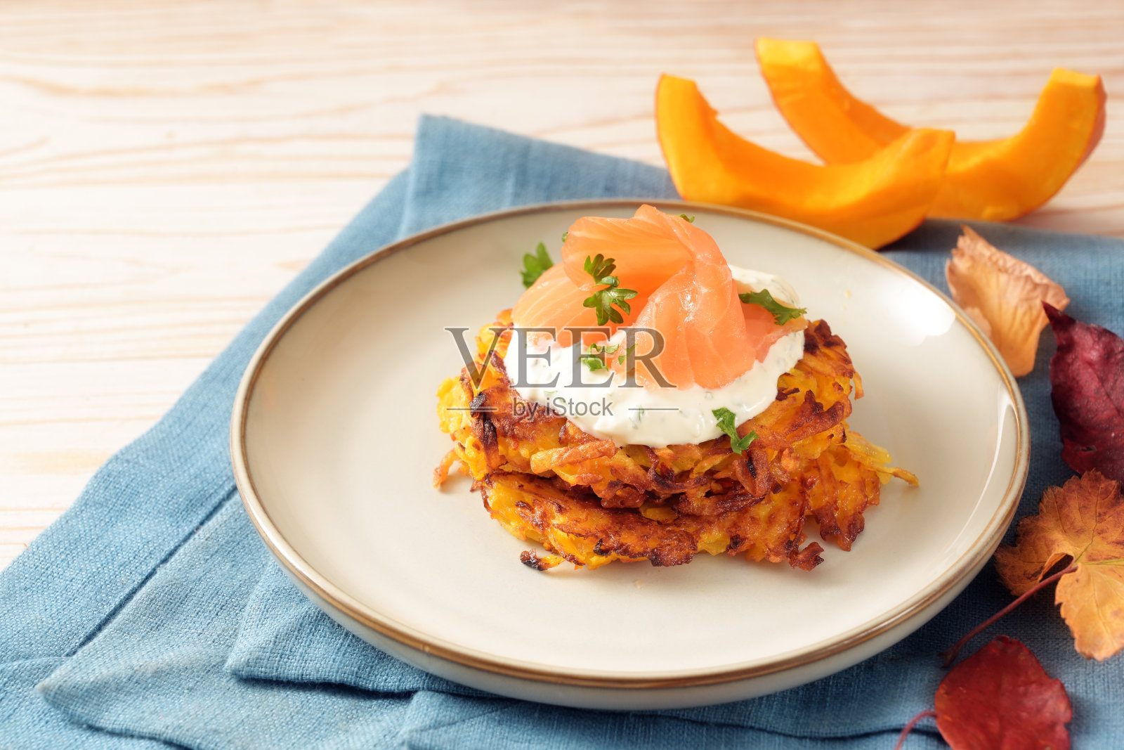 蔬菜油饼或煎饼，土豆和红咖喱南瓜奶油芝士酱和烟熏三文鱼，感恩节和万圣节的秋季开胃菜，复制空间，选定重点照片摄影图片