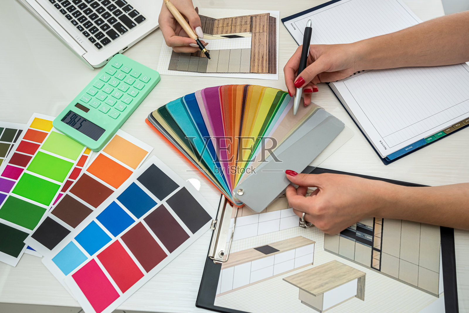 两位身穿白色衬衫的女员工在宽敞的桌子上设计新房间照片摄影图片