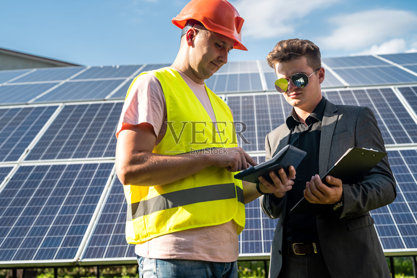 工人和客户在讨论每个太阳能电池板的项目成本照片摄影图片