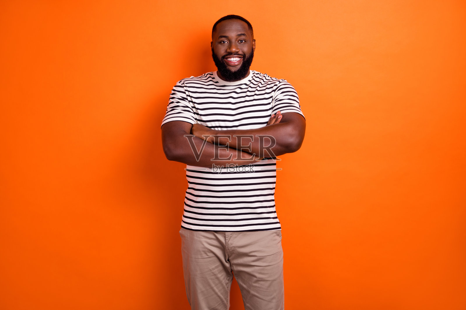 年轻乐观的非洲人的照片交叉的手穿休闲服孤立在橙色的背景照片摄影图片