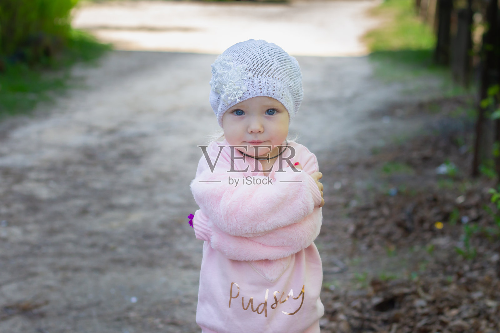 可爱的小女孩，2岁，穿着一件粉红色的软夹克在公园散步照片摄影图片