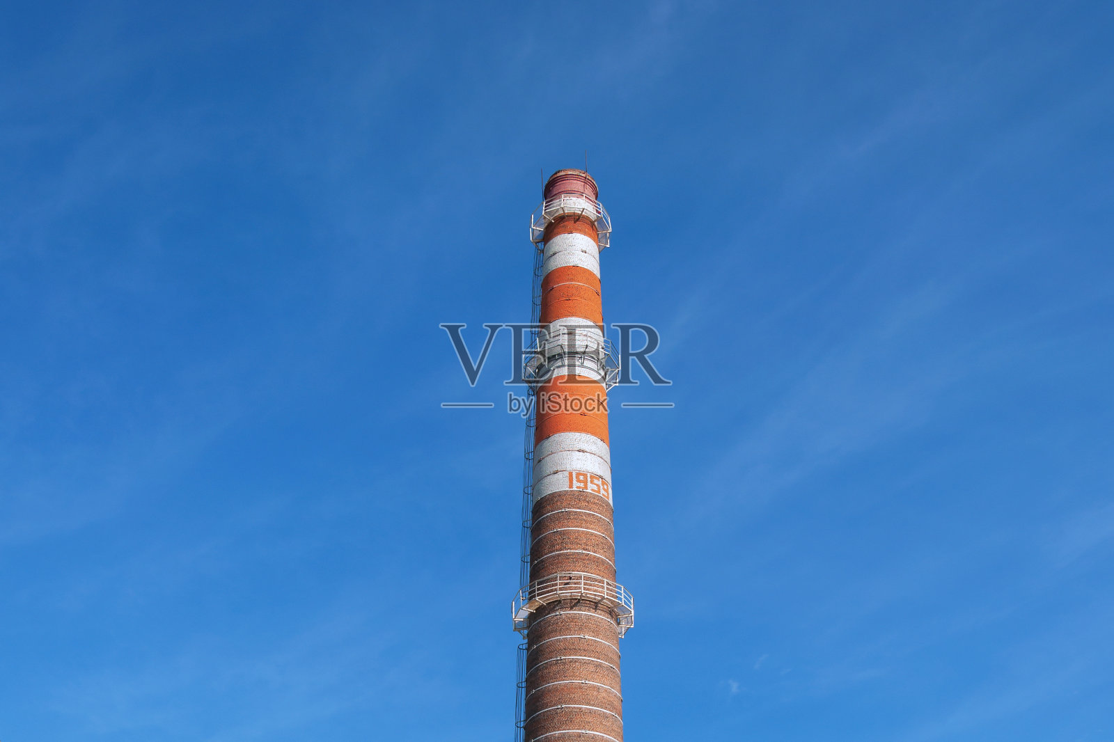 老工厂条纹，橙色，棕色，烟囱在蓝色天空的背景照片摄影图片