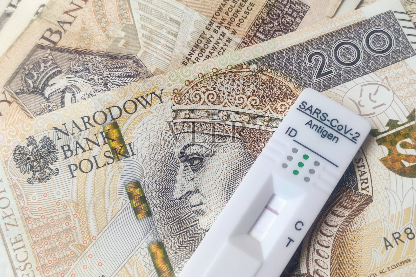 波兰货币的冠状病毒抗原快速检测。冠状病毒SARS-Cov-2快速阴性试验。测试磁带在几个欧元钞票的背景照片摄影图片