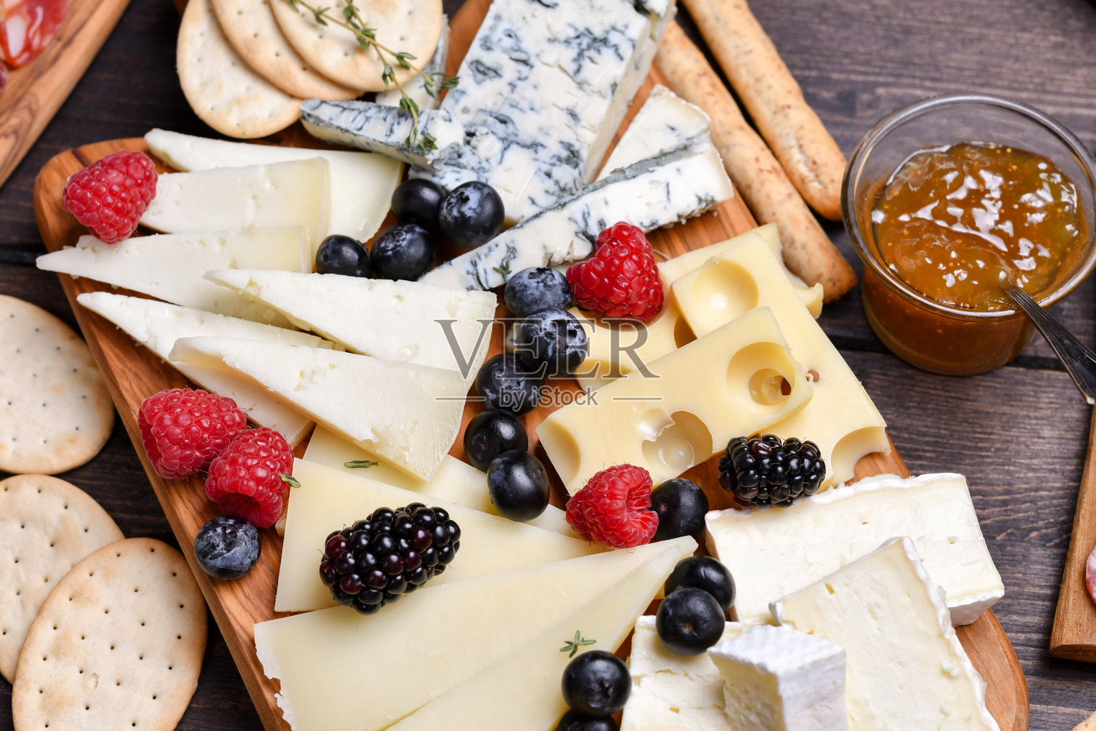 食物开胃菜，火腿，意大利腊肠，橄榄和格里西尼面包条。木板上的奶酪帕尔马干酪，佩科里诺干酪，戈尔根佐拉干酪。熟食店。两杯白葡萄酒或普罗塞克葡萄酒照片摄影图片