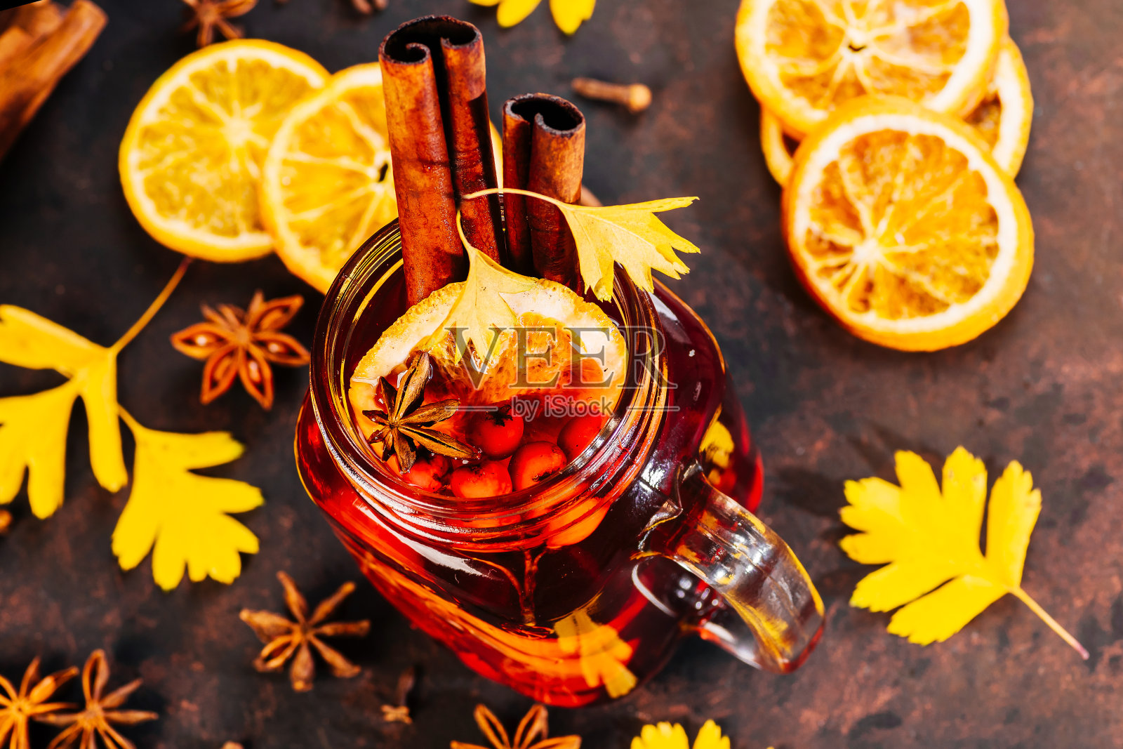 橙子干，肉桂棒和八角星在棕色的背景上。季节性的圣诞热饮料。烹饪或圣诞节装饰的配料。俯瞰圣诞餐桌上的热酒热酒。照片摄影图片